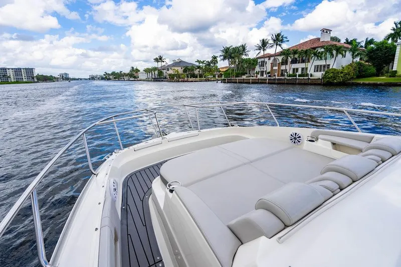 Slide: The Image of 2021 Sea Ray Sundancer 320 Outboard cruising near waterfront homes under a partly cloudy sky. - 19