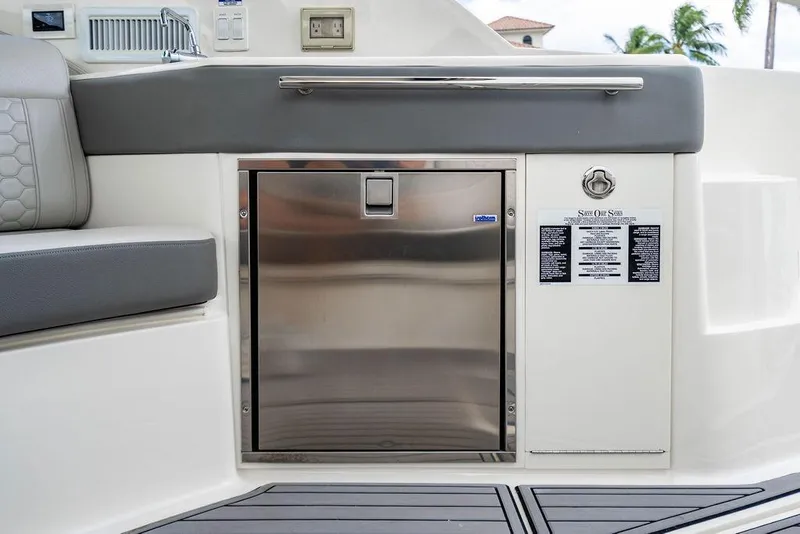 Slide: The Image of 2021 Sea Ray Sundancer 320 Outboard interior with stainless steel fridge and seating. - 28