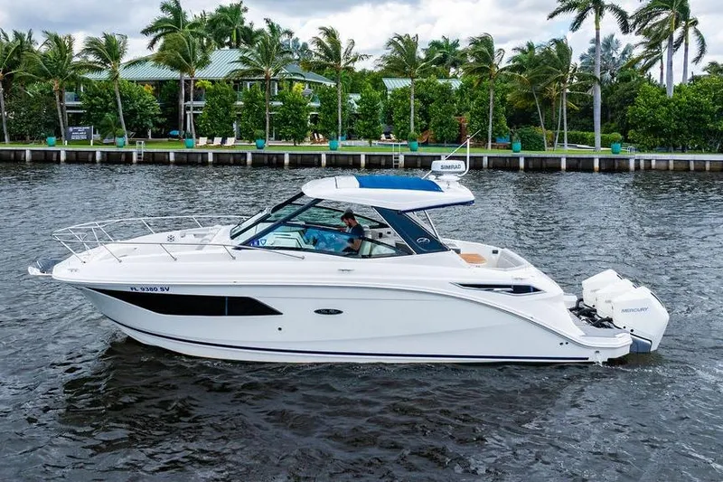 Slide: The Image of 2021 Sea Ray Sundancer 320 Outboard cruising on a scenic waterway with palm trees. - 3