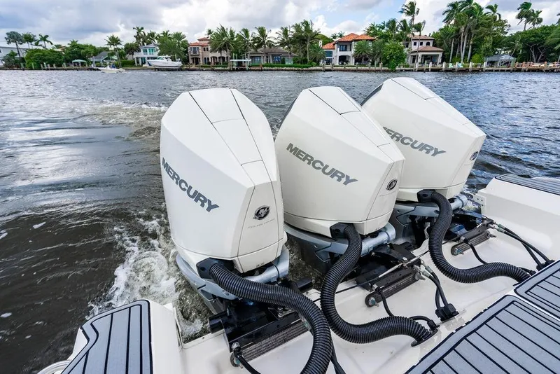 Slide: The Image of 2021 Sea Ray Sundancer 320 Outboard with triple Mercury engines cruising on a scenic waterway. - 31