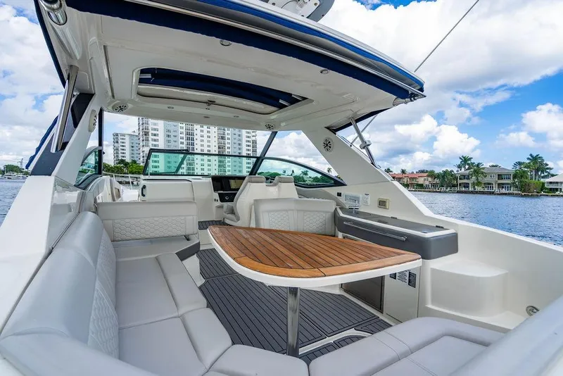 Slide: The Image of 2021 Sea Ray Sundancer 320 Outboard interior with elegant seating and wooden table. - 35
