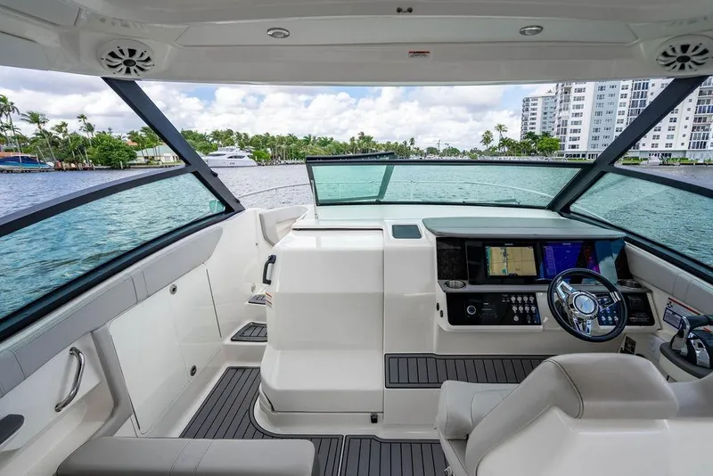 Slide: The Image of 2021 Sea Ray Sundancer 320 Outboard helm with modern controls and waterfront view. - 36