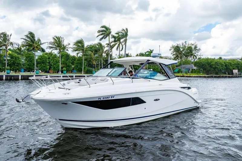 Slide: The Image of 2021 Sea Ray Sundancer 320 Outboard cruising on a scenic waterway with palm trees. - 4