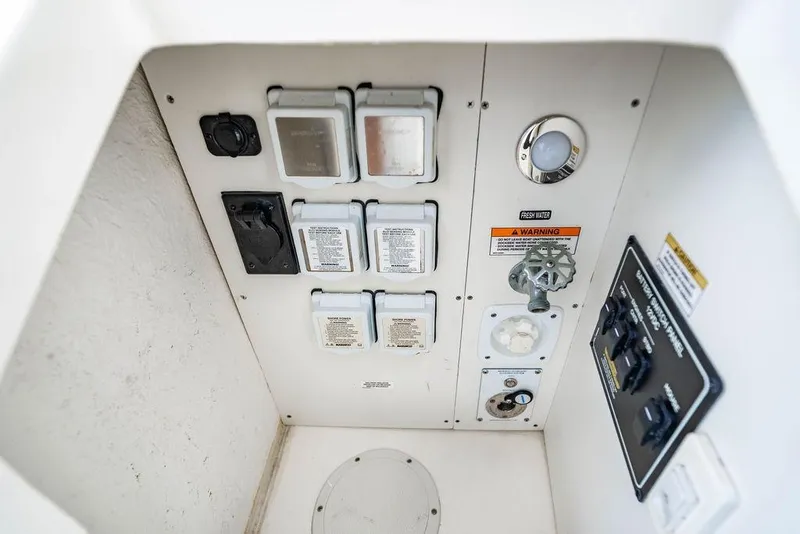 Slide: The Image of Control panel of 2021 Sea Ray Sundancer 320 Outboard with switches and water connections. - 48