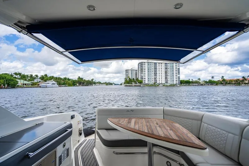 Slide: The Image of 2021 Sea Ray Sundancer 320 Outboard with waterfront view, featuring luxury seating and canopy. - 50