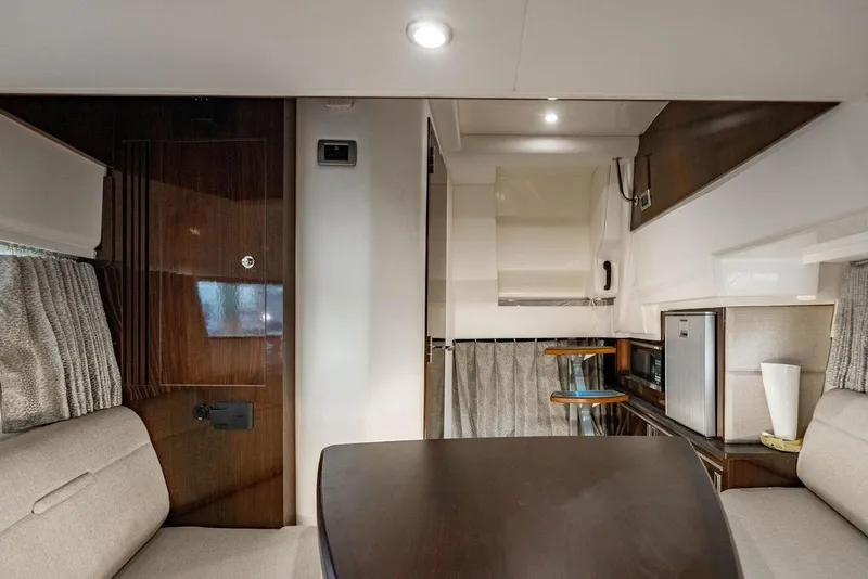 Slide: The Image of 2021 Sea Ray Sundancer 320 Outboard interior with modern seating and kitchenette. - 57