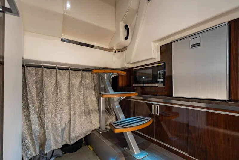 Slide: The Image of 2021 Sea Ray Sundancer 320 Outboard interior with modern kitchenette and stylish wooden steps. - 58