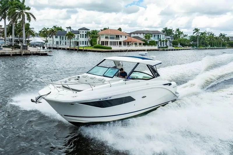 Slide: The Image of 2021 Sea Ray Sundancer 320 Outboard cruising on a scenic waterway with luxury homes. - 6