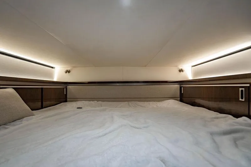 Slide: The Image of Interior cabin of 2021 Sea Ray Sundancer 320 Outboard, featuring cozy bedding and ambient lighting. - 61