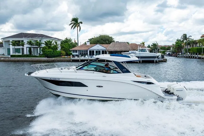 Slide: The Image of 2021 Sea Ray Sundancer 320 Outboard cruising on a scenic waterway with luxury homes. - 9