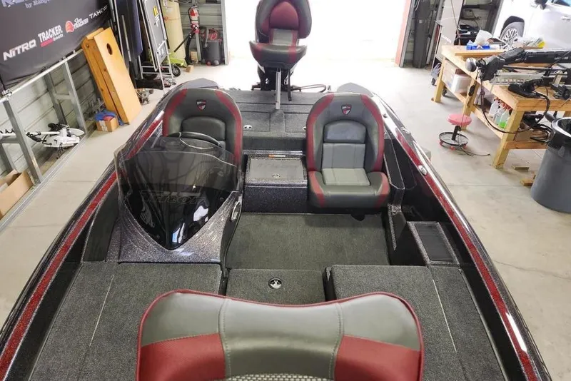 Slide: The Image of 2026 Triton 179 TrX boat interior with dual seats and steering console in a garage setting. - 10