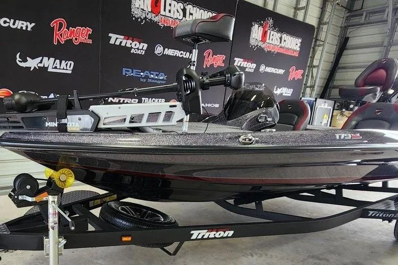 Slide: The Image of 2026 Triton 179 TrX boat displayed indoors with promotional banners in the background. - 13