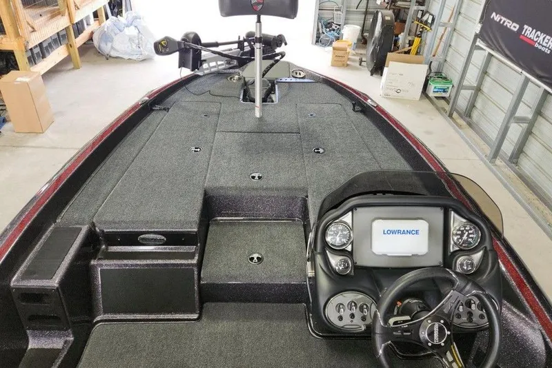 Slide: The Image of 2026 Triton 179 TrX boat interior with Lowrance navigation system in a garage setting. - 3