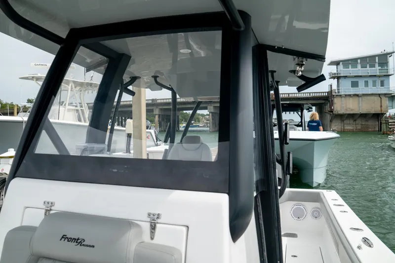 Slide: The Image of 2026 Front Runner 33' Center Console boat docked near a bridge. - 16