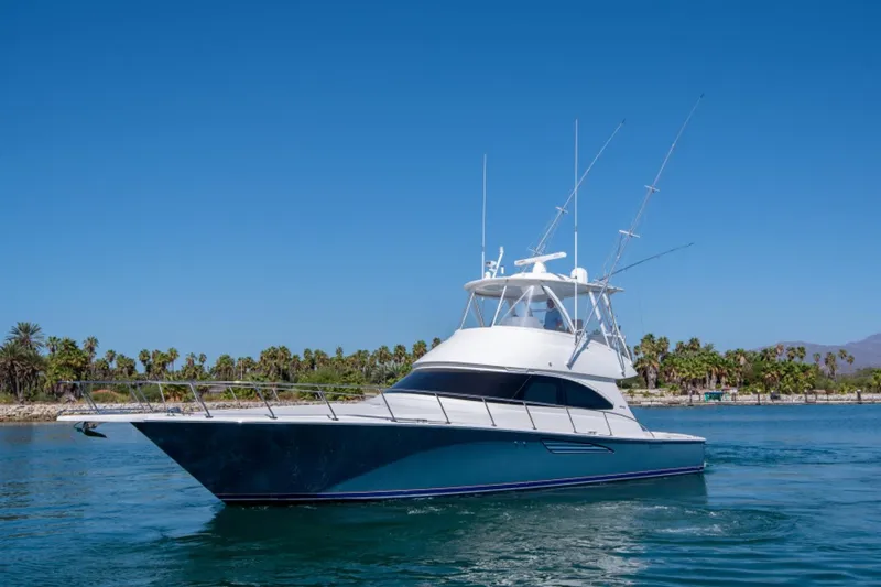 The Image of 2017 Viking 48 Convertible yacht cruising on a sunny day, surrounded by palm trees. - 0