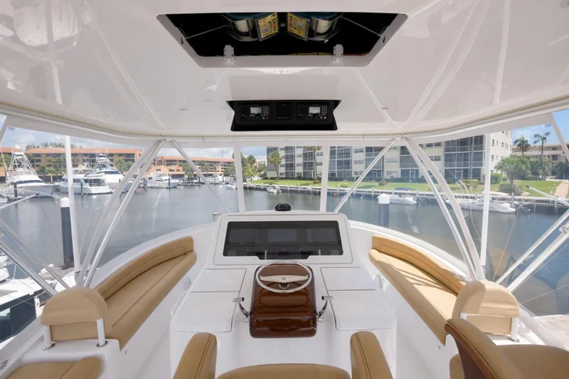 Slide: The Image of Interior view of 2017 Viking 48 Convertible yacht helm with marina backdrop. - 18