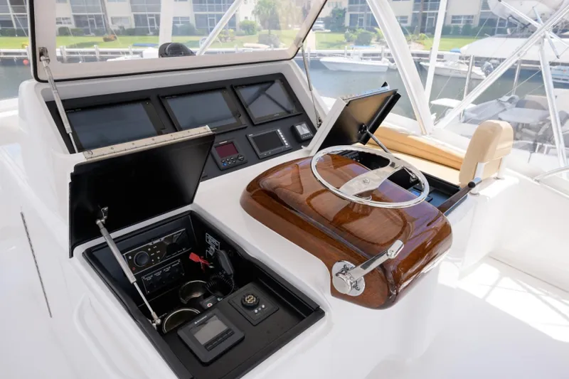 Slide: The Image of Control panel of 2017 Viking 48 Convertible yacht with steering wheel and navigation screens. - 19