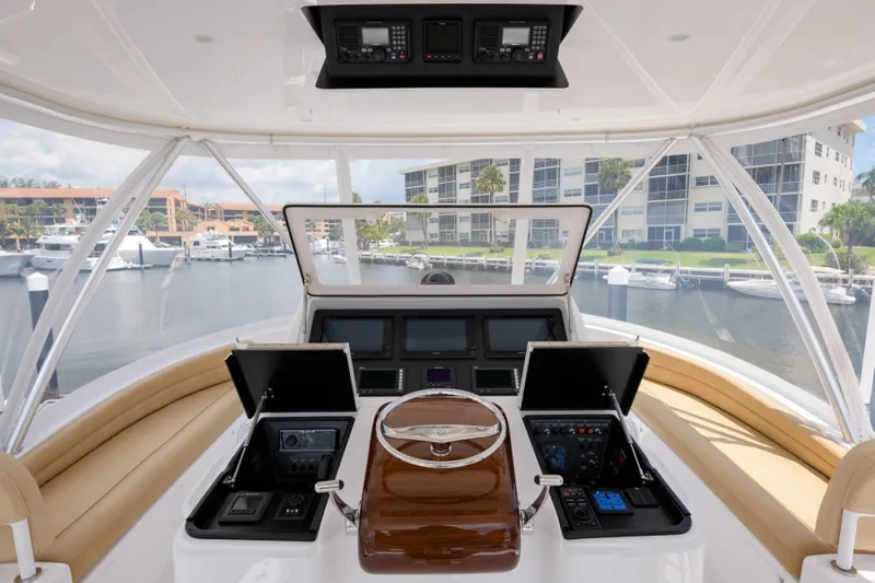 Slide: The Image of Helm of 2017 Viking 48 Convertible yacht with modern controls and marina view. - 20