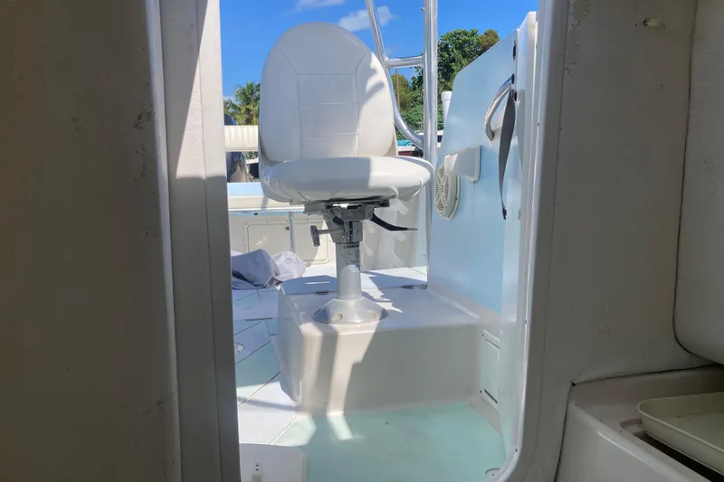 Slide: The Image of 1997 Pro-Line 255 boat interior with white captain's chair and blue sky background. - 10