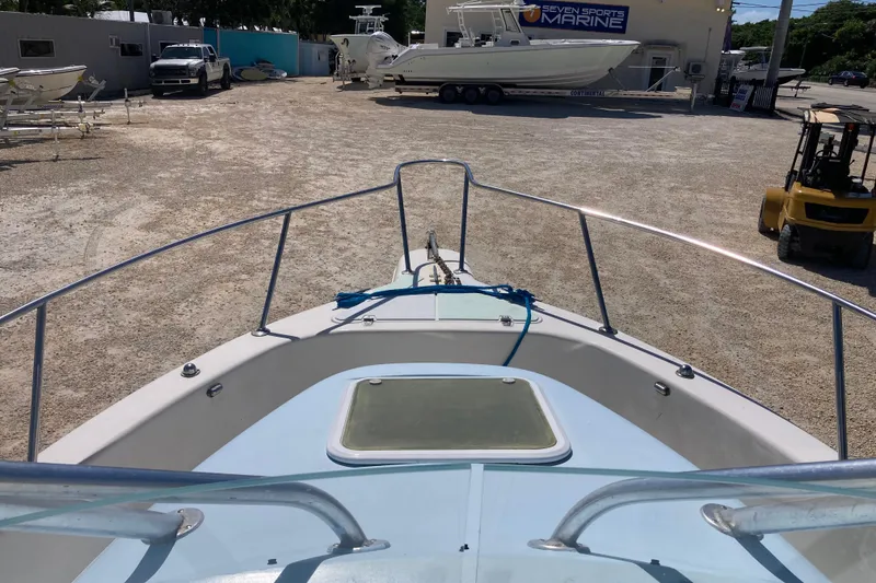 Slide: The Image of 1997 Pro-Line 255 boat in a marine yard, surrounded by other boats and equipment. - 11