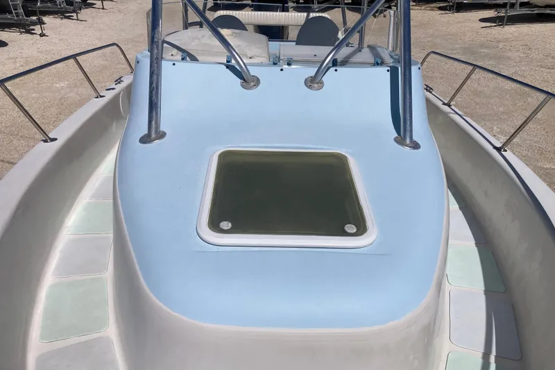 Slide: The Image of 1997 Pro-Line 255 boat deck with blue and white design, featuring a central hatch. - 13