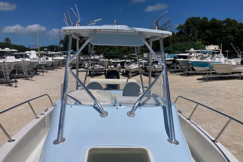 Slide: The Image of 1997 Pro-Line 255 boat with T-top, parked in a marina under clear blue skies. - 14