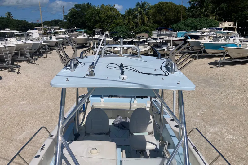 Slide: The Image of 1997 Pro-Line 255 boat in a marina, surrounded by other vessels under a clear sky. - 15