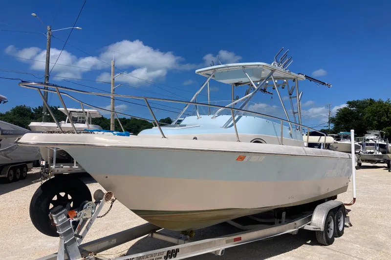 Slide: The Image of 1997 Pro-Line 255 boat on trailer under clear blue sky. - 4