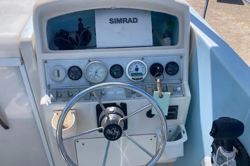 Slide: The Image of 1997 Pro-Line 255 boat dashboard with steering wheel and Simrad navigation system. - 7
