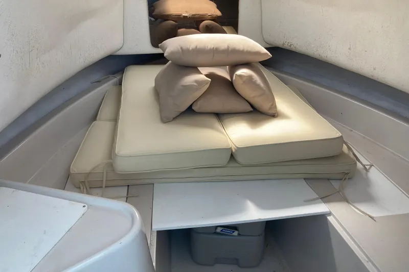 Slide: The Image of Interior cabin of a 1997 Pro-Line 255 boat with beige cushions and pillows. - 9