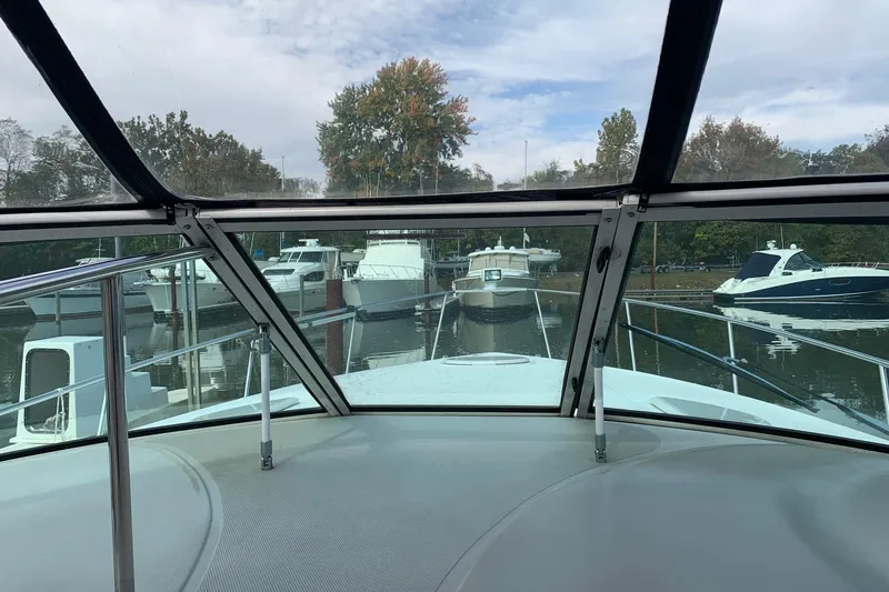 Slide: The Image of 2002 Cruisers 3275 Express yacht view from cockpit, docked among other boats. - 12