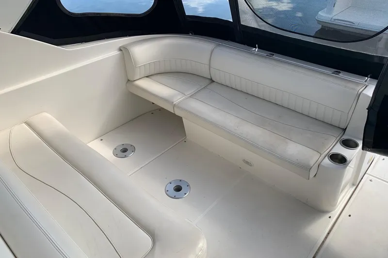 Slide: The Image of 2002 Cruisers 3275 Express boat interior with white seating and cup holders. - 16