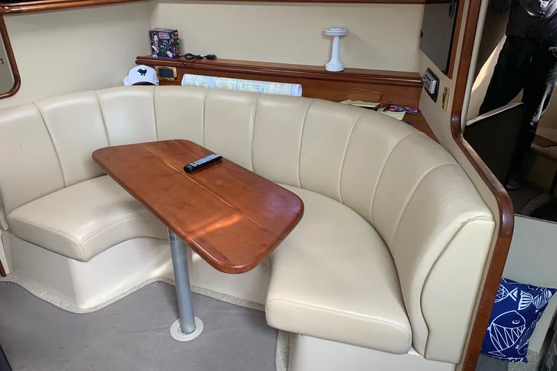 Slide: The Image of Interior of 2002 Cruisers 3275 Express yacht with beige seating and wooden table. - 21