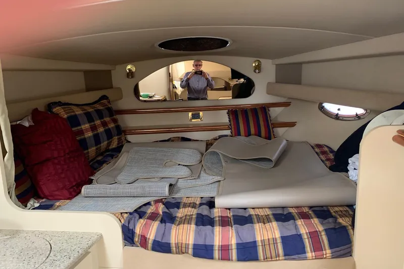 Slide: The Image of 2002 Cruisers 3275 Express cabin interior with plaid bedding and rolled-up mats. - 22