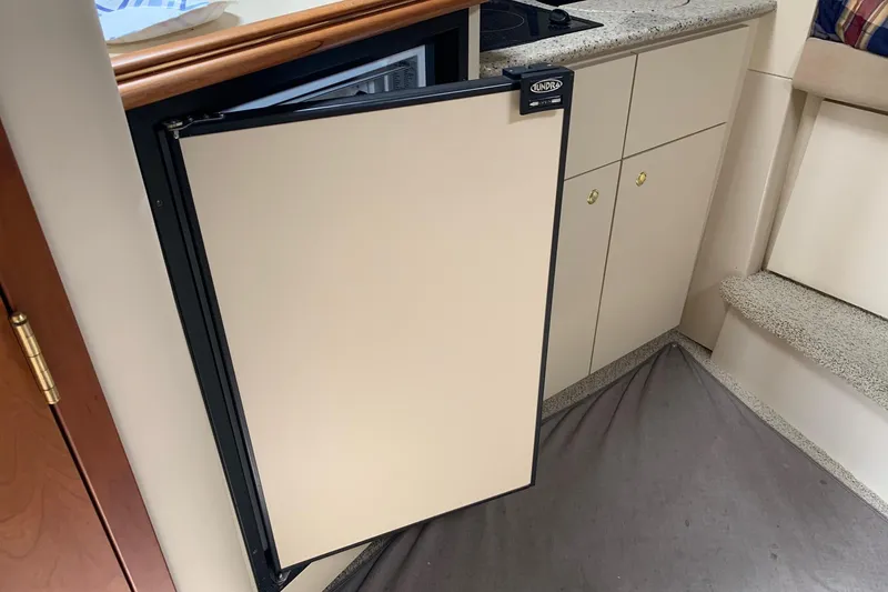 Slide: The Image of 2002 Cruisers 3275 Express yacht interior with open fridge and kitchenette. - 25
