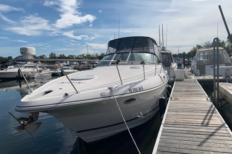 Slide: The Image of 2002 Cruisers 3275 Express docked at marina under clear blue sky. - 3