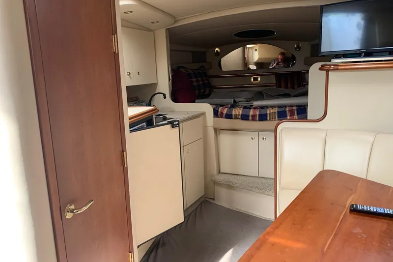 Slide: The Image of 2002 Cruisers 3275 Express cabin interior with kitchenette, bed, and TV. - 34