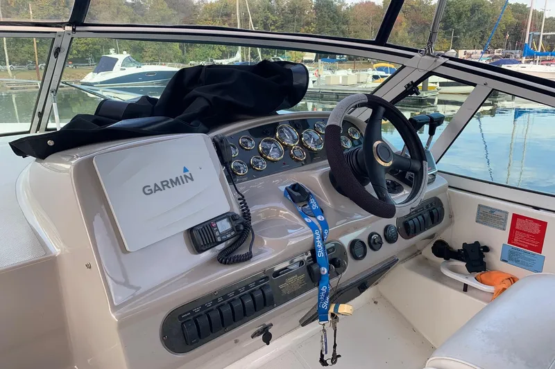 Slide: The Image of 2002 Cruisers 3275 Express boat helm with Garmin navigation system and steering wheel. - 13