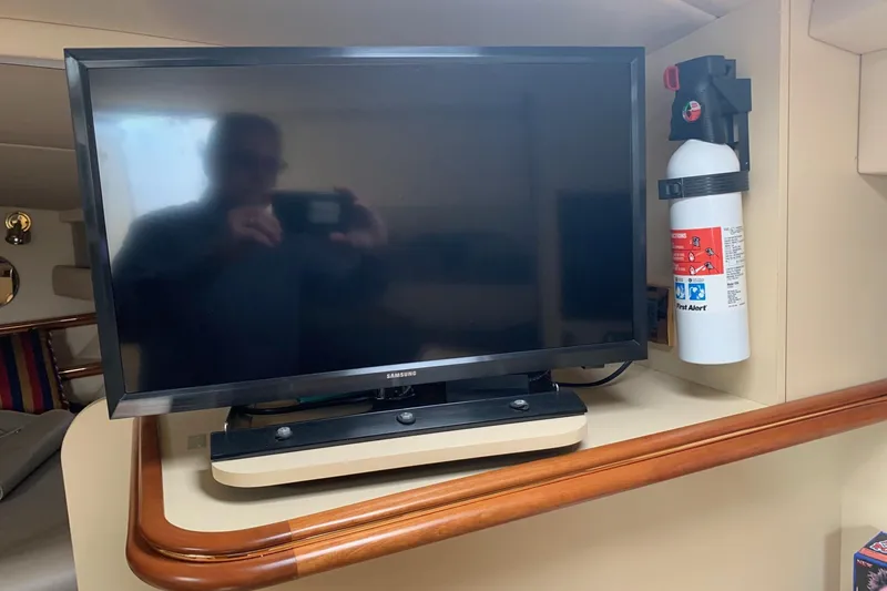 Slide: The Image of 2002 Cruisers 3275 Express cabin with TV and fire extinguisher. - 27