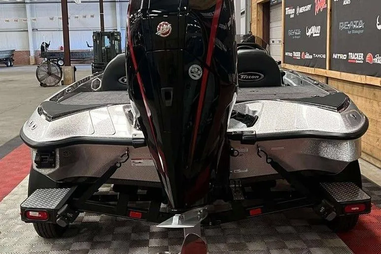 Slide: The Image of 2026 Triton 18 TrX boat in showroom, rear view with powerful outboard motor. - 3