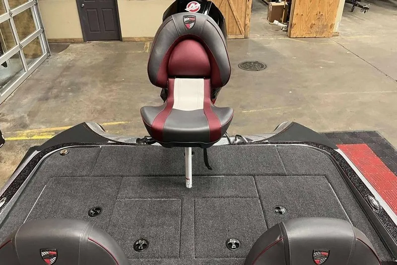 Slide: The Image of 2026 Triton 18 TrX boat interior with red and gray seating in a garage setting. - 9