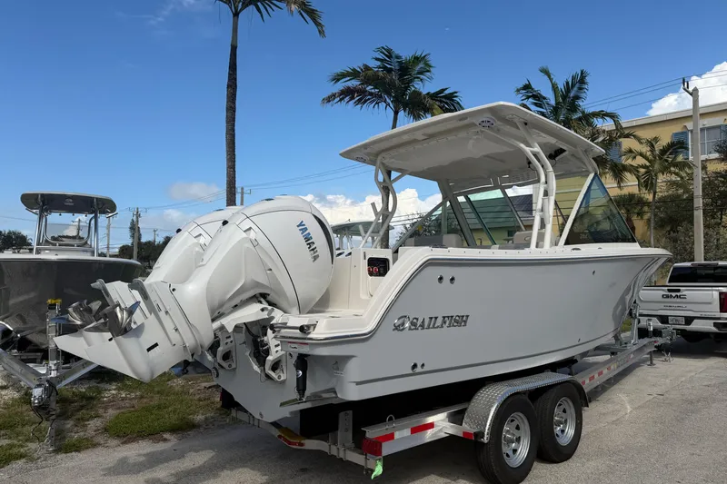 Slide: The Image of 2026 Sailfish 276 DC boat on trailer with Yamaha engine, parked near palm trees. - 4