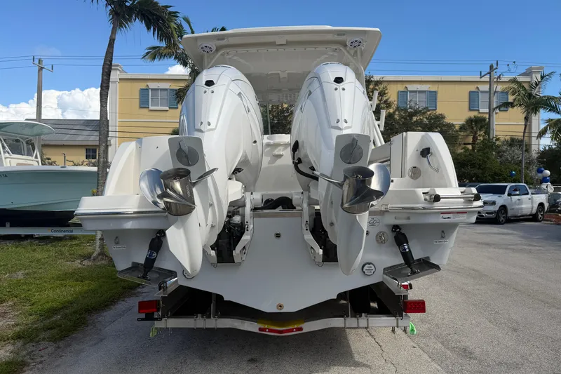 Slide: The Image of 2026 Sailfish 276 DC boat with dual outboard engines, parked on a sunny day. - 6