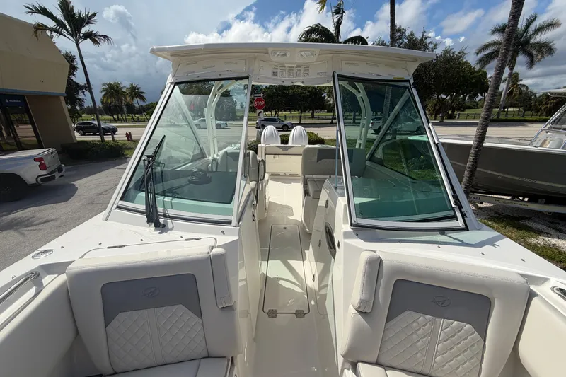 Slide: The Image of 2026 Sailfish 276 DC boat interior with seating, windshield, and dashboard under sunny skies. - 9