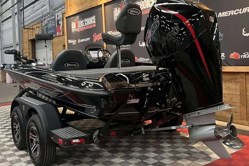 Slide: The Image of 2025 Triton 18 TrX boat with powerful outboard motor on display indoors. - 3