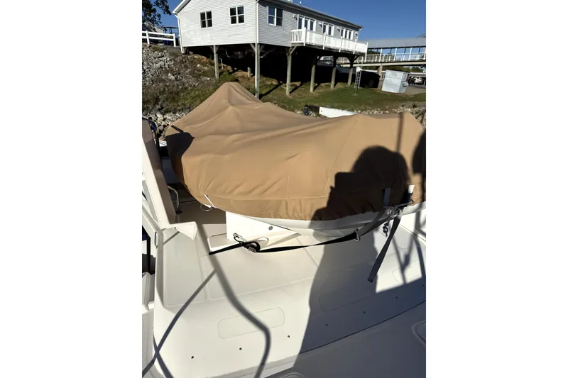 Slide: The Image of 2022 Ranger Tugs 43-CB boat with covered equipment on deck, near a waterfront house. - 21