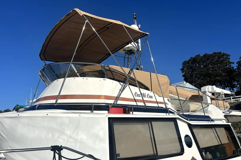 Slide: The Image of 2022 Ranger Tugs 43-CB boat with canopy, docked under clear blue sky. - 7