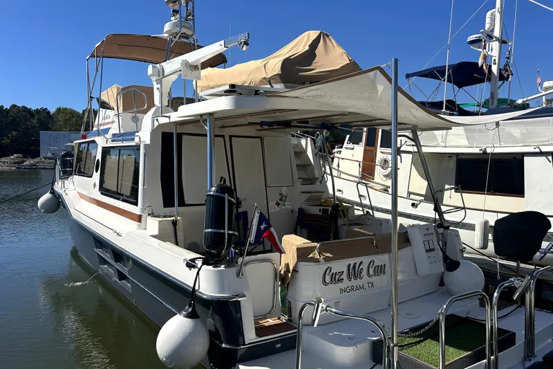 Slide: The Image of 2022 Ranger Tugs 43-CB yacht docked, featuring a spacious deck and canopy. - 8