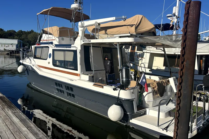 Slide: The Image of 2022 Ranger Tugs 43-CB docked at marina, featuring spacious deck and modern design. - 11