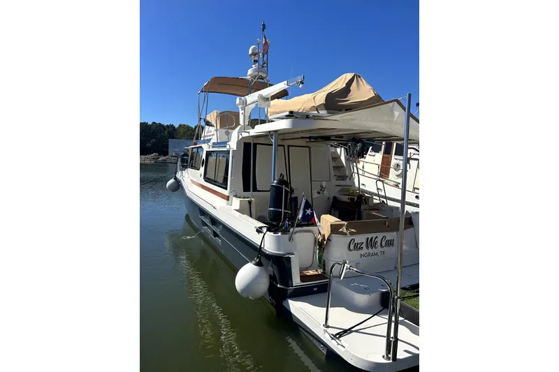 Slide: The Image of 2022 Ranger Tugs 43-CB boat docked, featuring a spacious deck and canopy. - 9
